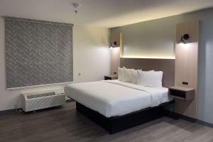 Un dormitorio con una gran cama blanca y una ventana en MainStay Suites Columbia Harbison, en Columbia