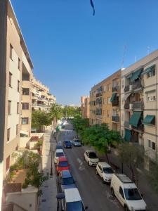 una calle de la ciudad con coches estacionados al lado de los edificios en Acogedor apartamento valencia 3 dormitorios, en Aldaia