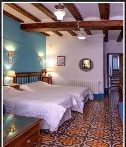 1 dormitorio con 2 camas en una habitación con paredes azules en Casa Valor, en Penàguila