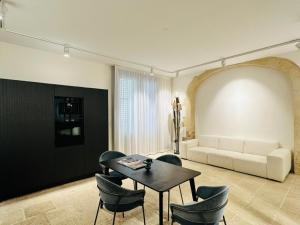 sala de estar con mesa, sillas y sofá en La Dépendance Hotel, en Noto