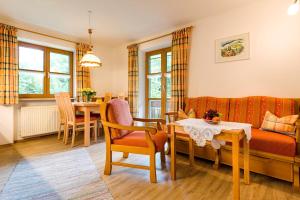 a living room with a couch and a table and chairs at Landhaus Bachtelmühle in Bolsterlang