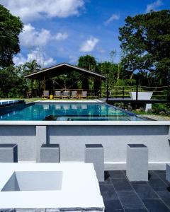 a swimming pool with a table and a pavilion at Silk Cotton Cottages in Parrot Hall