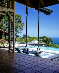 a swing in a pool with the ocean in the background at Silk Cotton Cottages in Parrot Hall