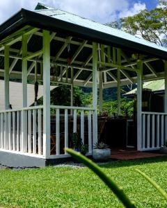 a pavilion with a green roof on a lawn at Silk Cotton Cottages in Parrot Hall