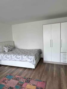 a white bedroom with a bed and a cabinet at 500 Meter vom Bahnhof entfernt in Fellbach