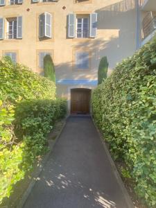 uma passagem em frente a um edifício com uma porta de madeira em T3 Aix sud avec terrasse et parking em Aix-en-Provence