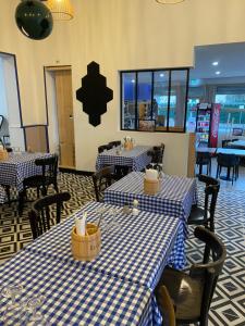 a restaurant with blue and white checked tables and chairs at Hôtel L'Arbousier in Soulac-sur-Mer +21 photos