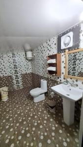 a bathroom with a sink and a toilet in it at Mannat Corbett Resort in Rāmnagar