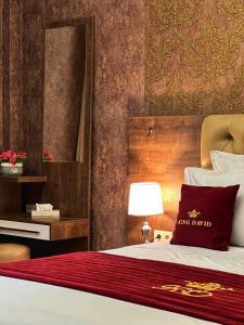 Dormitorio con cama con espejo y lámpara en Hotel King David The Builder, en Kutaisi