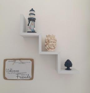 a wall with shelves with a statue and a trophy at Borgata Mazzarelli in Marina di Ragusa