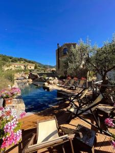 a group of chairs sitting on a deck next to a river at Antico Borgo Buonanotte in San Mauro Castelverde