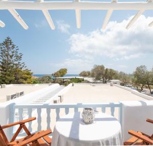 a table on a balcony with a view of the ocean at Agrari Ninemia Mykonos in Agrari