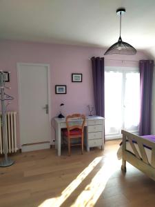 1 dormitorio con escritorio, silla y ventana en Entre mer et bocage, en Coutances