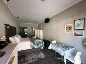 a bedroom with a bed and a sink and a bathroom at Midway En Route in Harrismith