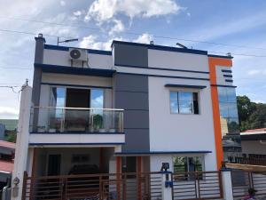 uma casa azul e branca com uma varanda em Jaleen Transient em Batangas City