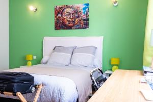 - une chambre avec un lit orné d'une peinture murale dans l'établissement Escale villa, à Marignane