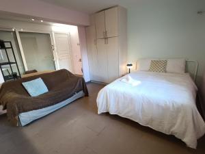 a bedroom with a large white bed and a window at Nearby alimos beatch in Athens