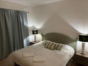 sypialnia z łóżkiem z dwoma lampami na dwóch stołach w obiekcie Villa GALVANA w mieście Guia