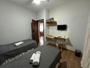 Zimmer mit 2 Betten und einem Schreibtisch mit einem Computer in der Unterkunft Villa do Aconchego · Próxima ao centro São João da Boa Vista · Casa inteira in São João da Boa Vista