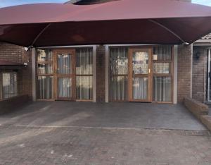 a garage with awning and doors on a brick building at Midway En Route in Harrismith