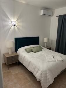 um quarto com uma cama branca com duas mesas de cabeceira em Villa GALVANA na Guia