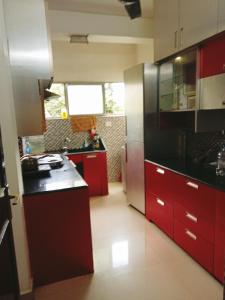 a kitchen with red cabinets and black counter tops at happystay@casablanca2 in Chennai