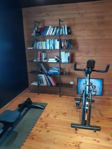 a room with a exercise bike and a book shelf at Escale villa in Marignane