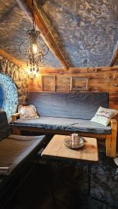 um quarto com um sofá, uma mesa e um lustre em Zemljane kućice Kreševo em Kreševo