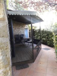 a wooden deck with a table and chairs on it at Appartement en pierre à proximité Lourmarin in Lauris