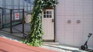 a door with ivy growing on the side of a building at almond hostel & cafe Shibuya in Tokyo