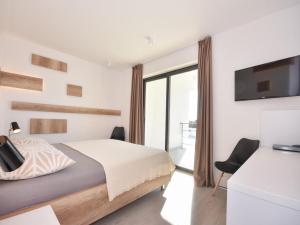 a bedroom with a bed and a tv on the wall at Villa Formosa in Kaštela