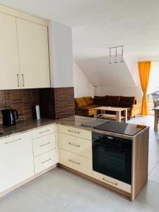 a kitchen with white cabinets and a stove top oven at Apartament Primula 1 in Jaworki