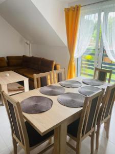 a dining room table with four plates on it at Apartament Primula 1 in Jaworki