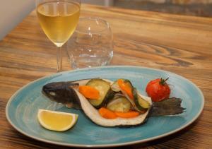a plate of food with a fish and vegetables on a table at Les Rives de l'Ain in Pont-de-Poitte