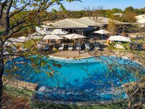 an overhead view of a swimming pool with umbrellas at Insika lodge in Victoria Falls