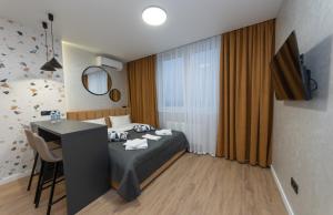 a bedroom with a bed and a desk and a table at MYFREEDOM Апартаменти ЖК NAVIGATOR in Kyiv