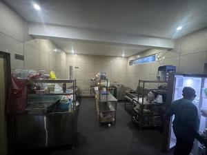 un homme debout dans une cuisine équipée d'un réfrigérateur dans l'établissement Coorg Jungle Mist, à Madikeri