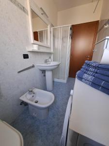 a bathroom with a sink and a toilet and a bed at Casa di Gabry in Cento