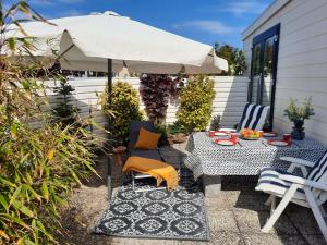 a patio with an umbrella and a table and chairs at Pinkie's in Buren