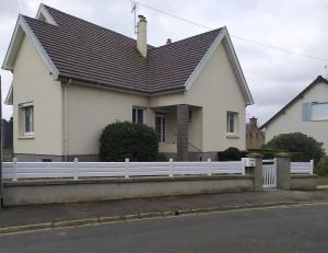 una casa blanca con una valla blanca en Entre mer et bocage, en Coutances