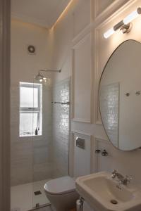 a bathroom with a toilet and a sink and a mirror at NOAH House in Cape Town