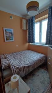ein kleines Schlafzimmer mit einem Bett und einem Fenster in der Unterkunft Apartament Warszawska in Włocławek