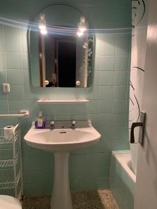 een badkamer met een wastafel, een spiegel en een bad bij Global La Cañada in Torrenueva
