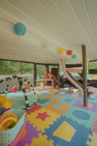 een speelkamer voor kinderen met een speelset en een speeltuin bij The Amazing Inácio Bus converted home in Sintra