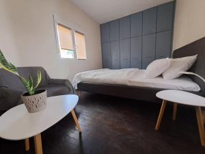1 dormitorio con cama, sofá y mesa en Parkview Central Apartment - Xanthi, en Xanthi