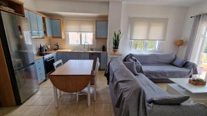 cocina y sala de estar con sofá y mesa en Nala's home en Porto Heli