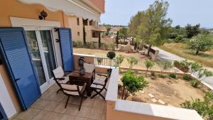 a balcony of a house with a table and chairs at Nala's home in Porto Heli