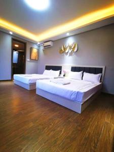 - 2 lits dans une chambre dotée de parquet dans l'établissement Peaceful ForestCity Fringe Villa 12 pax, à Kampong Tiram Duku