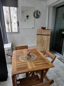 una mesa de madera y sillas en una cocina con mesa y ducha. en LE FLORIDE B Folco de baronchelli en Le Grau-du-Roi