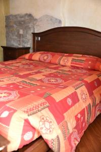 a bed with a colorful blanket on top of it at Agriturismo Grabbia in Grumo